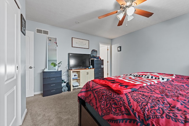 carpeted bedroom featuring ceiling fan and a textured ceiling