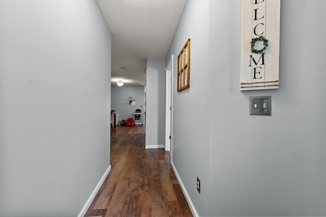 hall featuring dark hardwood / wood-style floors and a textured ceiling