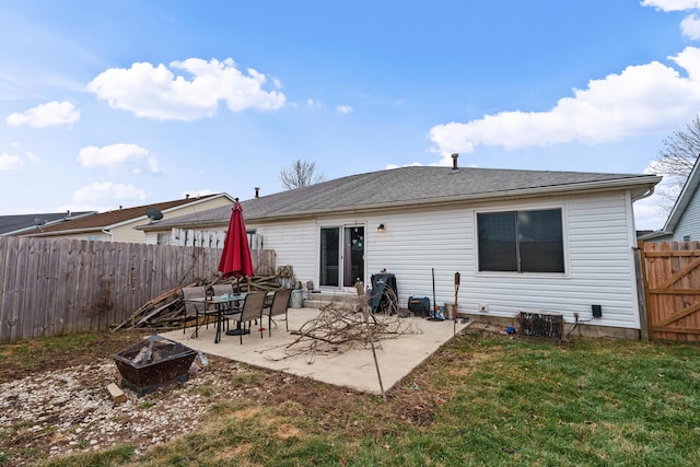 rear view of house with a patio, a yard, and an outdoor fire pit