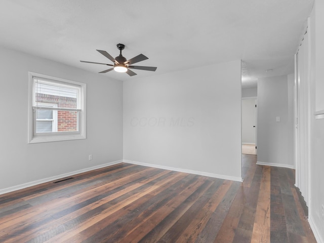 spare room with dark hardwood / wood-style floors and ceiling fan