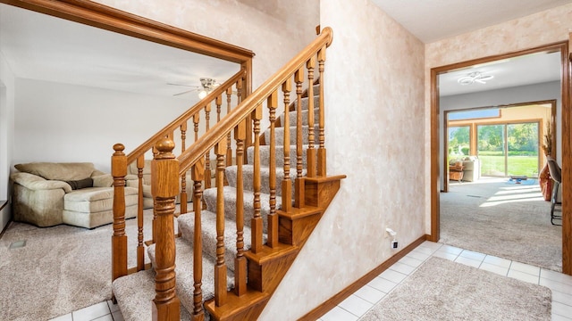 staircase featuring ceiling fan and carpet