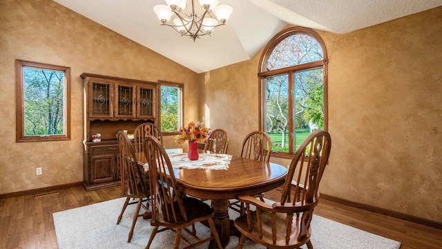 dining space featuring dark hardwood / wood-style floors, vaulted ceiling, and a notable chandelier