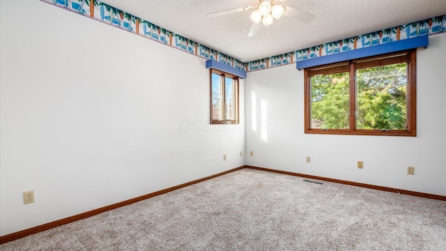 carpeted spare room featuring ceiling fan and a textured ceiling