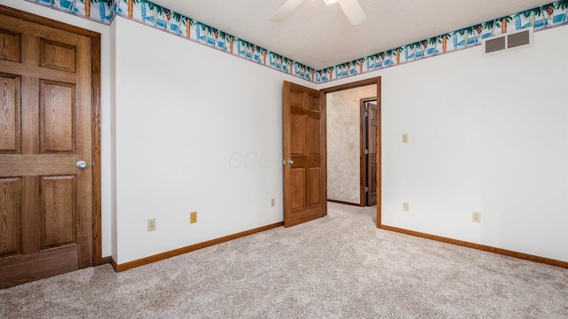 carpeted spare room with ceiling fan