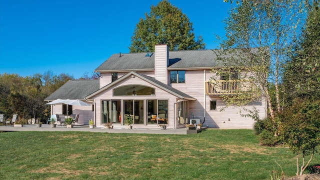 back of house with a patio and a lawn