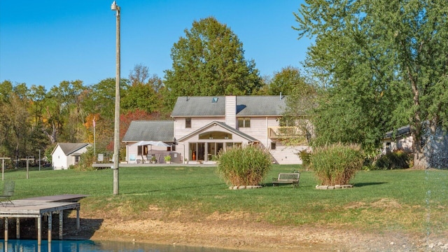 back of house with a patio area and a lawn