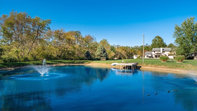 view of pool with a yard and a water view