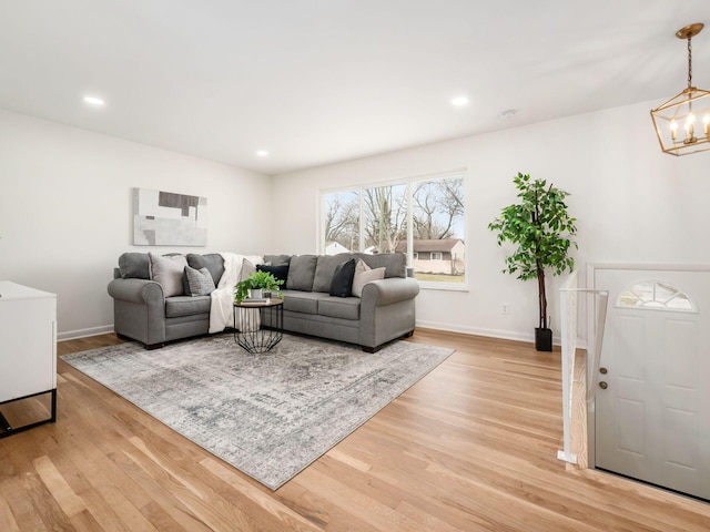 living room with a notable chandelier and light wood-type flooring