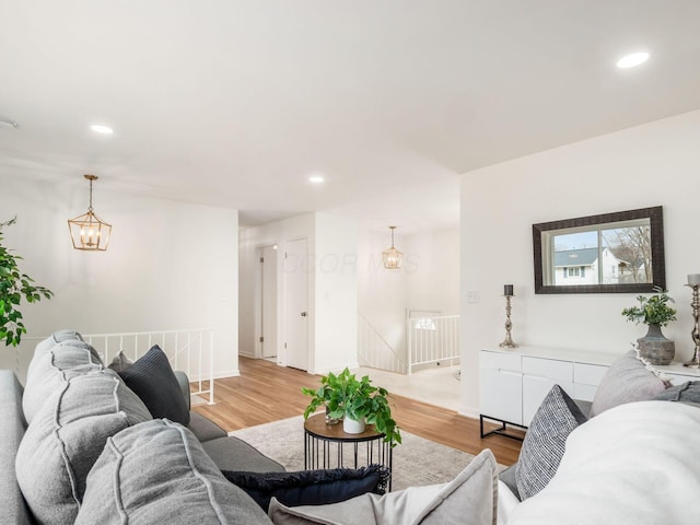 living room with a notable chandelier and light hardwood / wood-style floors