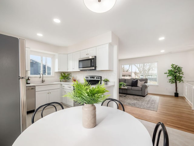 dining space with a healthy amount of sunlight, sink, and light hardwood / wood-style floors