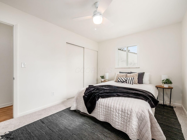 carpeted bedroom with ceiling fan and a closet