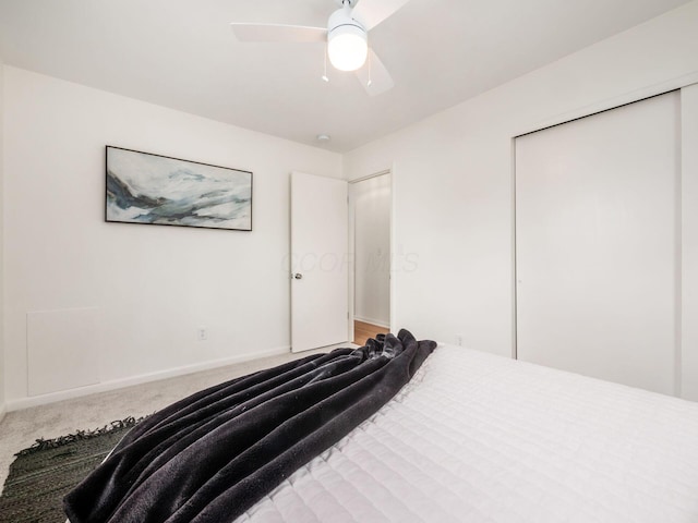 carpeted bedroom with ceiling fan and a closet