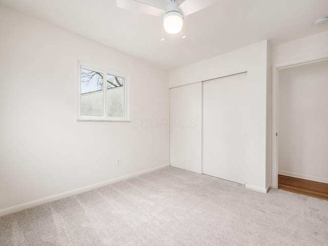 unfurnished bedroom with light carpet, ceiling fan, and a closet