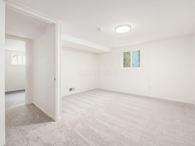 unfurnished room featuring plenty of natural light and light carpet