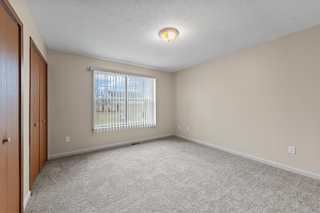 unfurnished bedroom with carpet flooring, a closet, and a textured ceiling