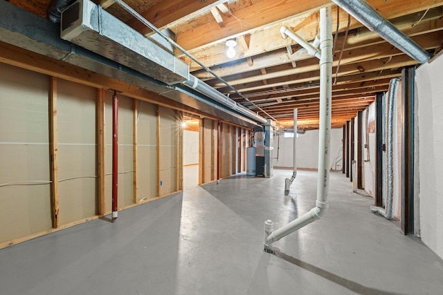 basement featuring water heater and heating unit