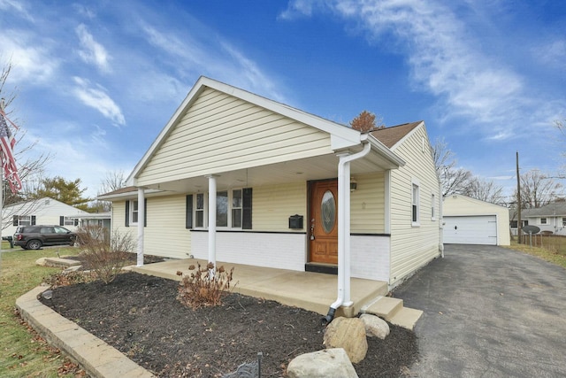 bungalow with a garage, an outdoor structure, and covered porch