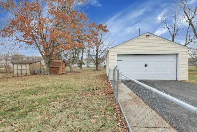 garage with central AC unit and a lawn