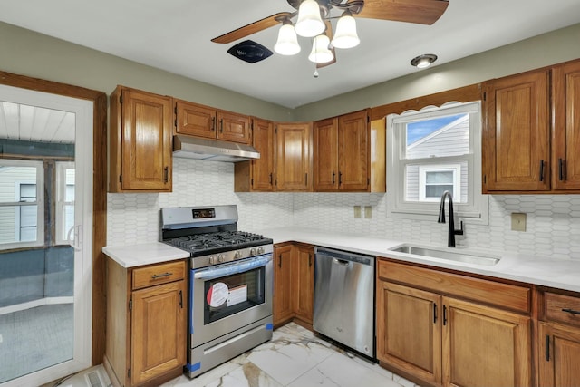 kitchen featuring appliances with stainless steel finishes, sink, ceiling fan, and decorative backsplash