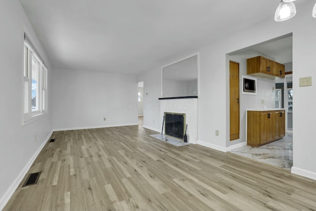 unfurnished living room with a fireplace and light hardwood / wood-style floors