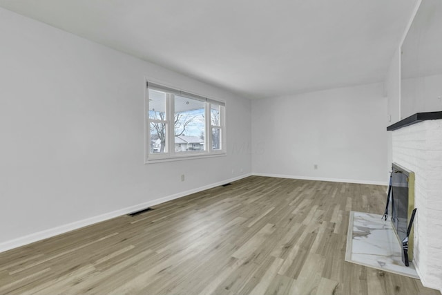 unfurnished living room with light wood-type flooring and a fireplace