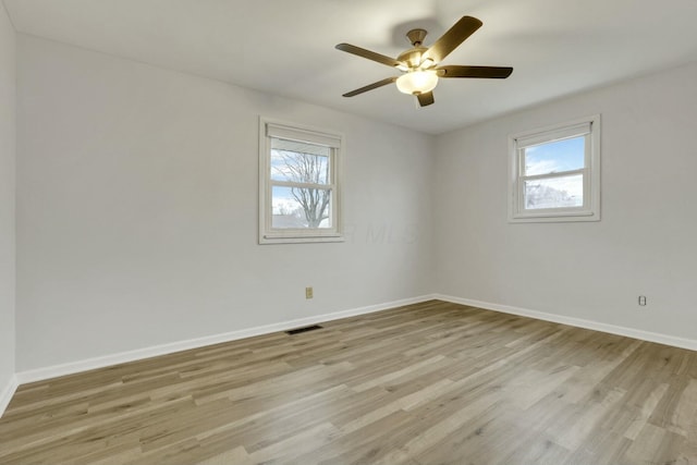 empty room featuring ceiling fan, light hardwood / wood-style floors, and a wealth of natural light