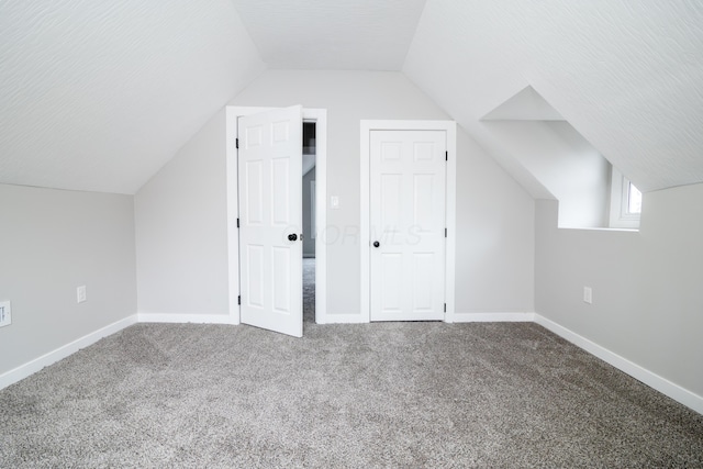 additional living space with vaulted ceiling and carpet