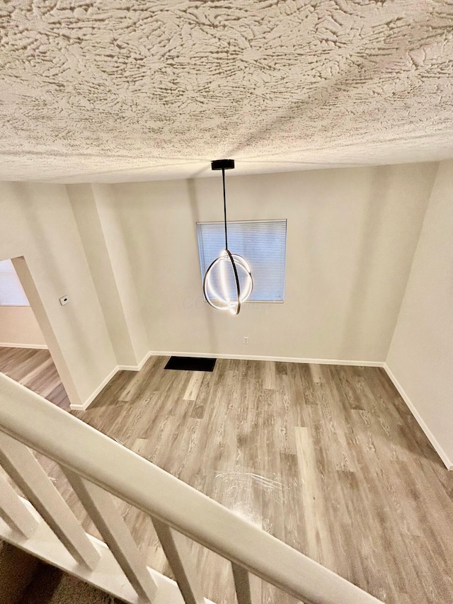 interior details featuring wood-type flooring and a textured ceiling