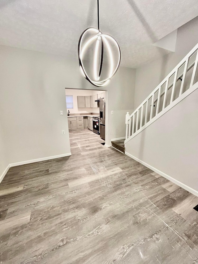 unfurnished dining area featuring hardwood / wood-style flooring, sink, and a textured ceiling