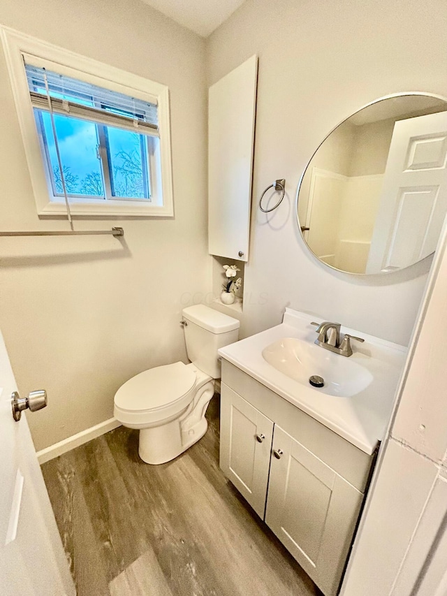 bathroom with wood-type flooring, vanity, and toilet