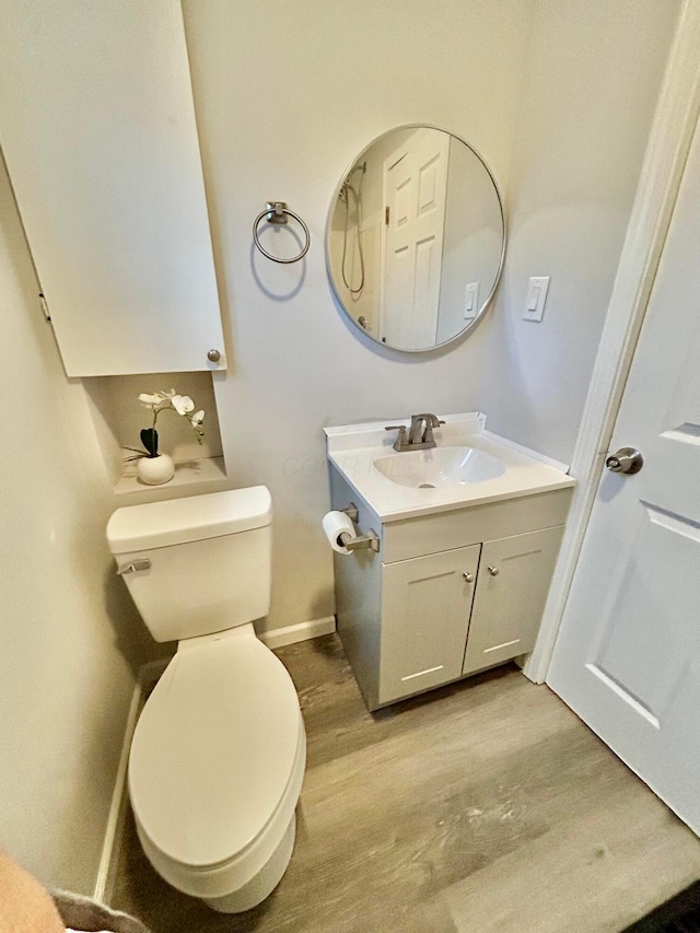 bathroom featuring vanity, hardwood / wood-style floors, and toilet