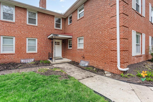 exterior space with a chimney and brick siding
