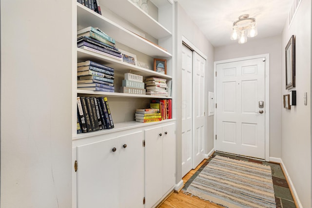 entryway with baseboards and light wood-style floors