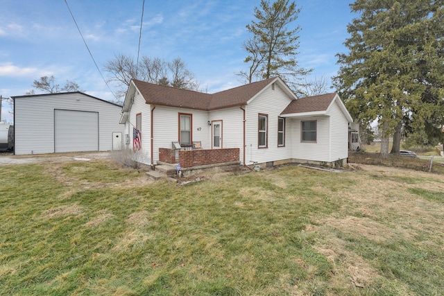 view of front of house featuring a garage, an outbuilding, and a front yard