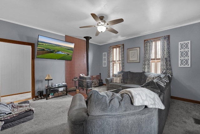 living room featuring crown molding, carpet floors, a wood stove, and ceiling fan