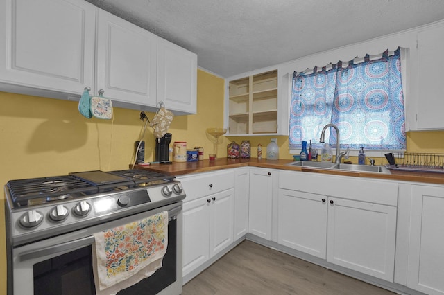 kitchen with white cabinetry, sink, and stainless steel range with gas stovetop