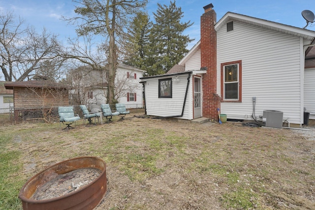 back of house featuring a yard and central air condition unit