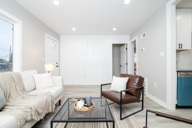 living room with plenty of natural light, light hardwood / wood-style floors, and bar area