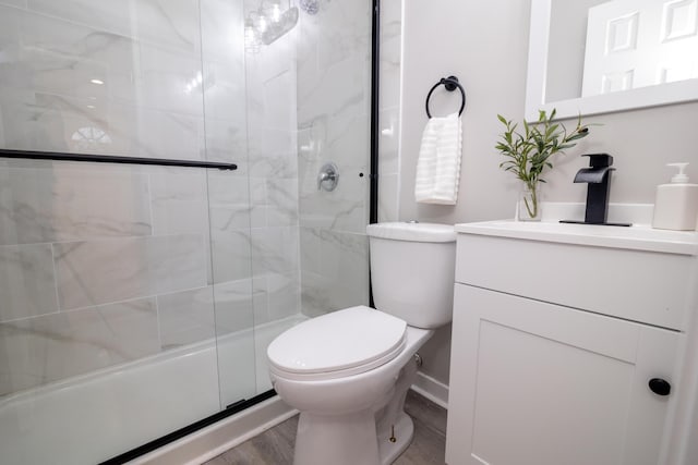 bathroom featuring vanity, toilet, an enclosed shower, and hardwood / wood-style floors