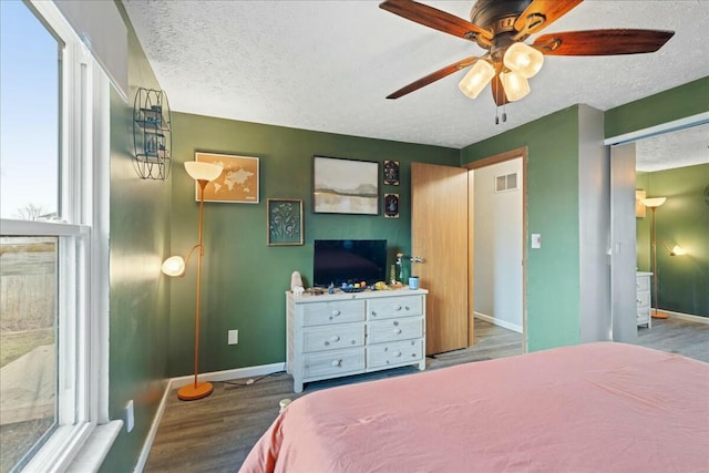 bedroom with hardwood / wood-style floors, a textured ceiling, and ceiling fan