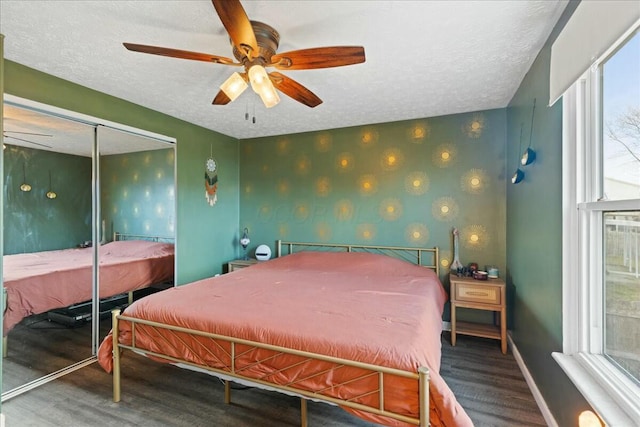 bedroom featuring hardwood / wood-style floors, a closet, a textured ceiling, and ceiling fan