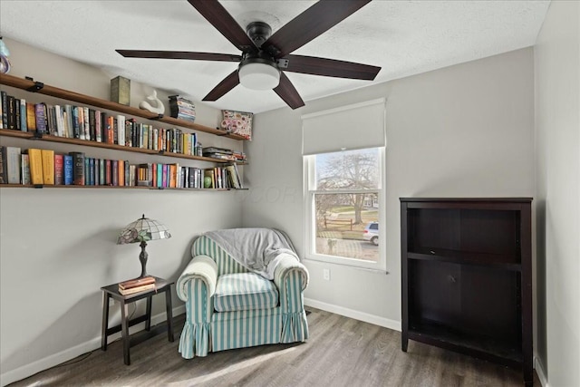 sitting room featuring ceiling fan, hardwood / wood-style flooring, and a textured ceiling