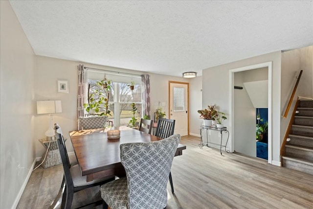 dining room featuring light hardwood / wood-style flooring and a textured ceiling