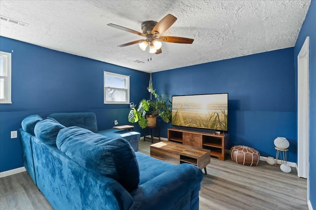 home theater room featuring hardwood / wood-style flooring, a textured ceiling, and ceiling fan