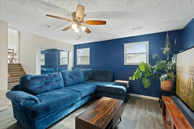 living room featuring a textured ceiling, wood-type flooring, and ceiling fan