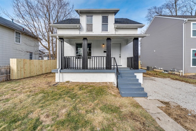 bungalow-style home with central AC unit, covered porch, and a front lawn