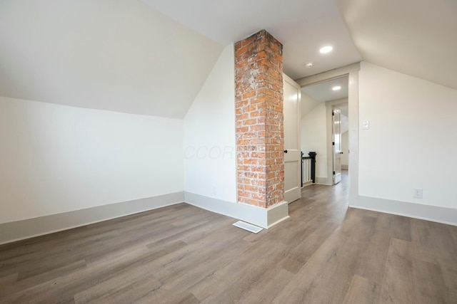 additional living space featuring wood-type flooring and lofted ceiling