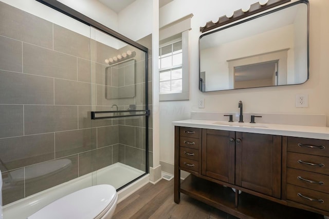 bathroom with vanity, wood-type flooring, toilet, and walk in shower