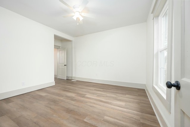 spare room with plenty of natural light, light hardwood / wood-style floors, and ceiling fan