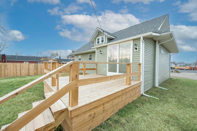 back of property featuring a deck and a lawn